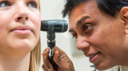 Doctor using a scope to look into patients ear.