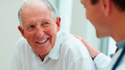 Older man smiling at doctor.