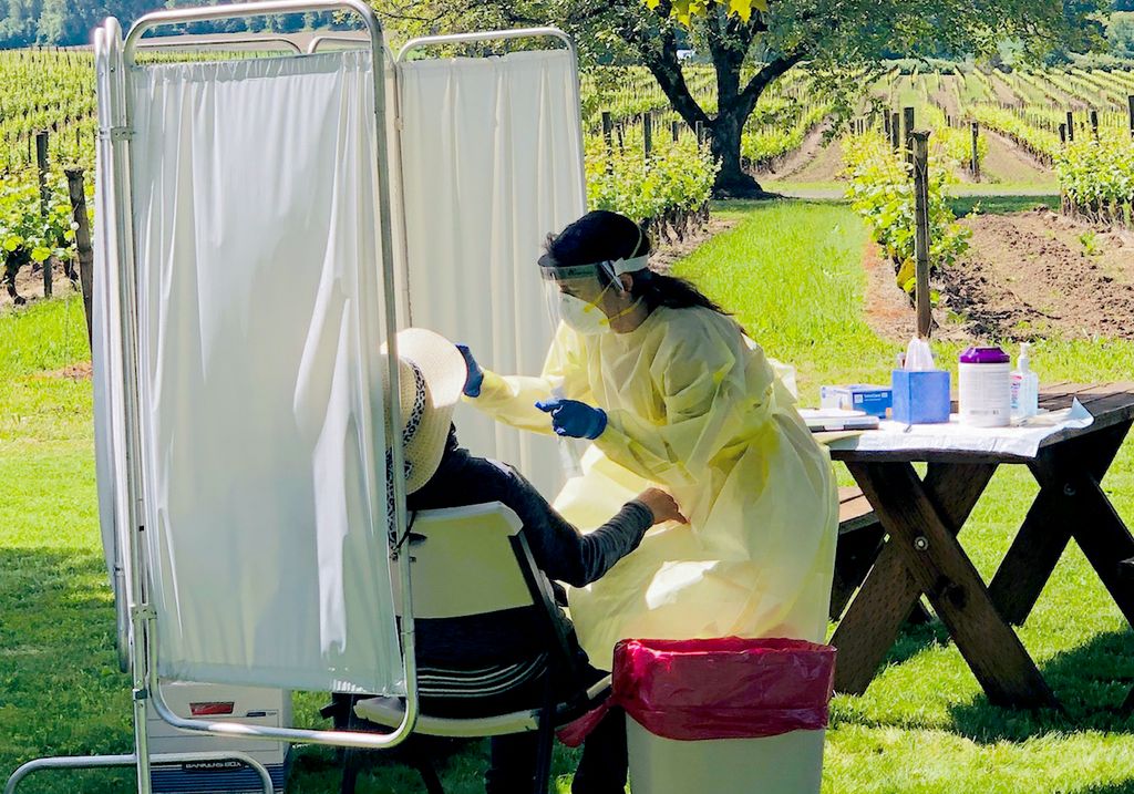 Salud staff screening seasonal worker in a vineyard.